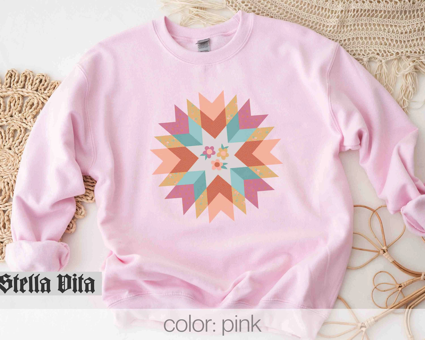 a pink sweatshirt with a colorful star design on it
