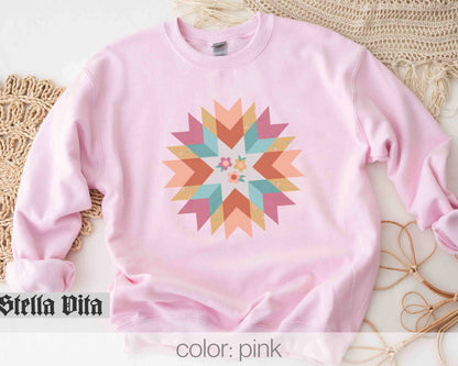 a pink sweatshirt with a colorful star design on it