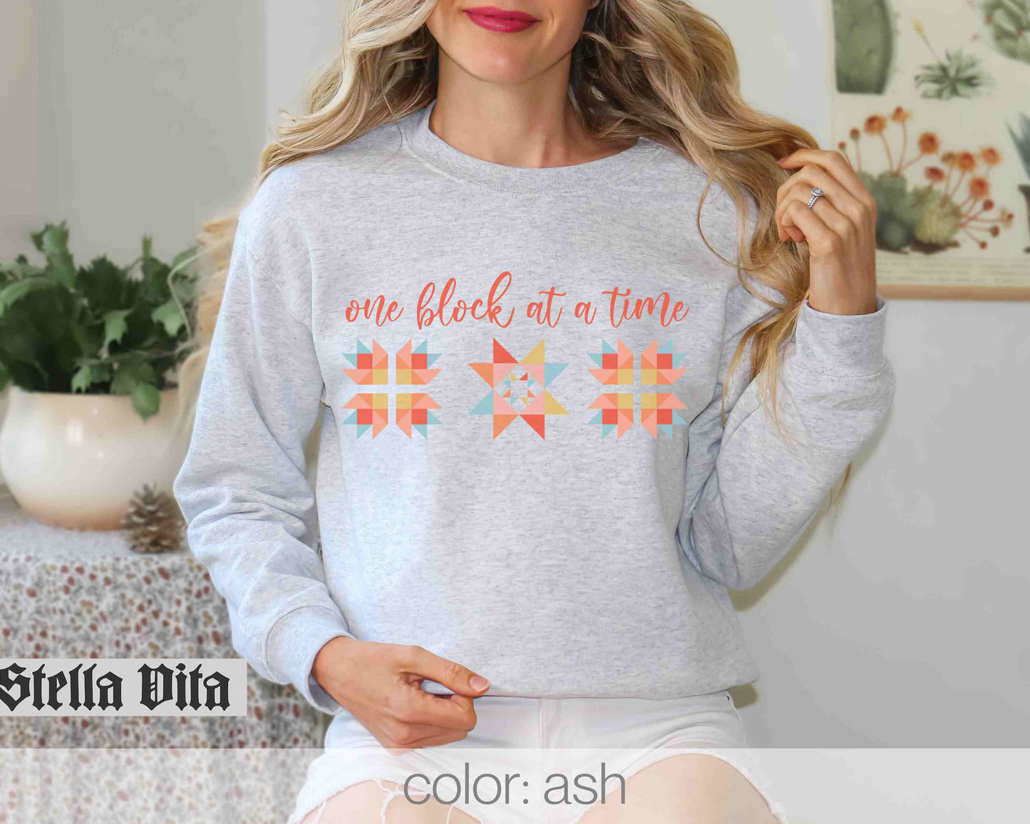 a woman wearing a sweatshirt that says one block at a time