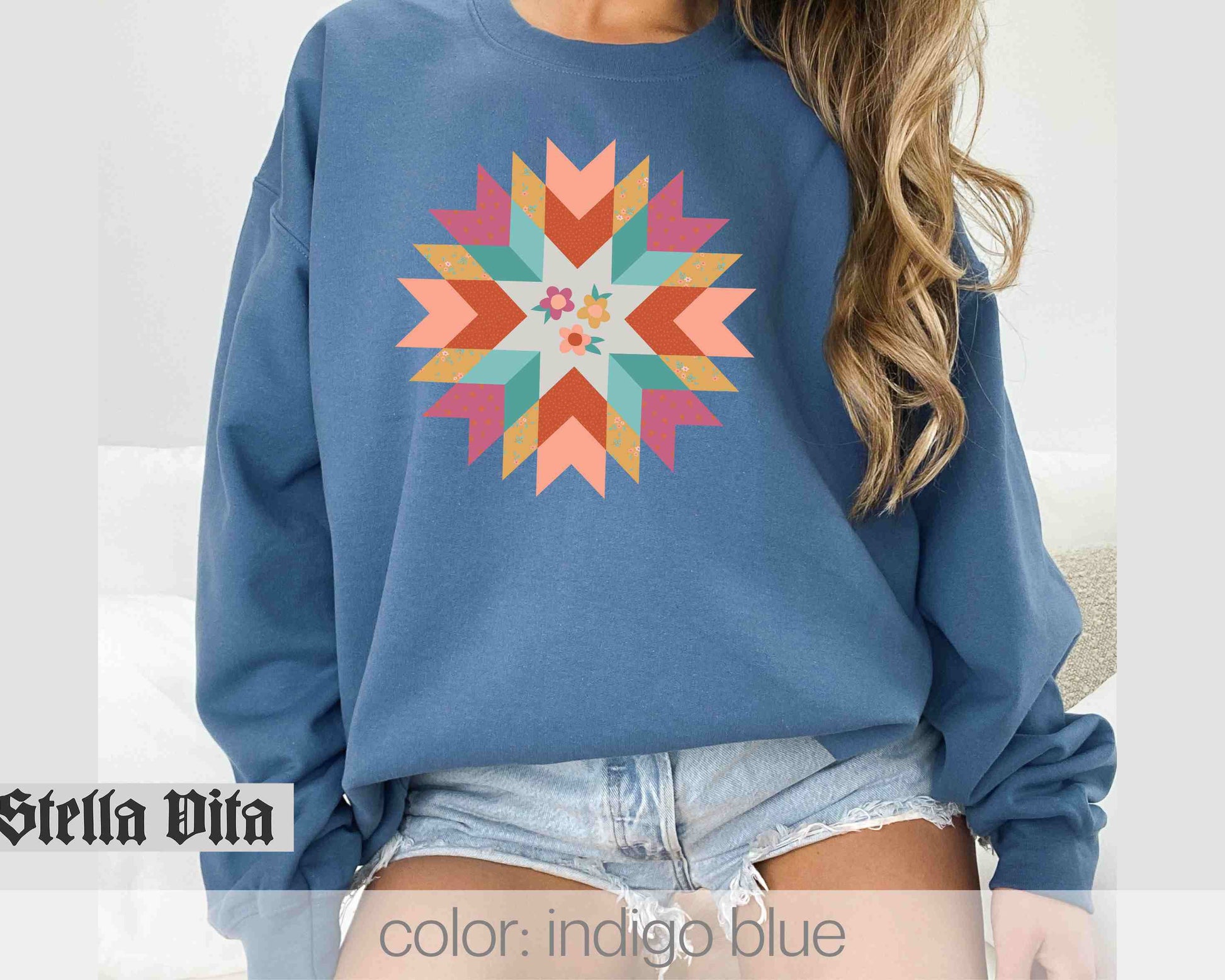 a woman wearing a blue sweatshirt with a colorful design on it