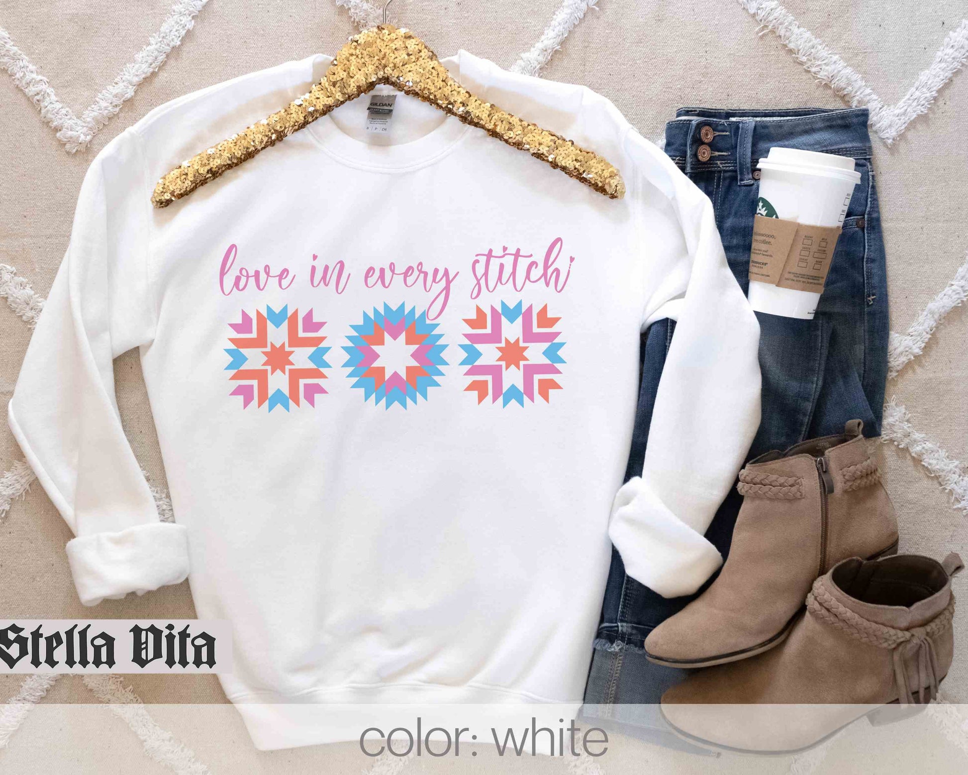a white sweater with a gold sequin trim and a pair of jeans